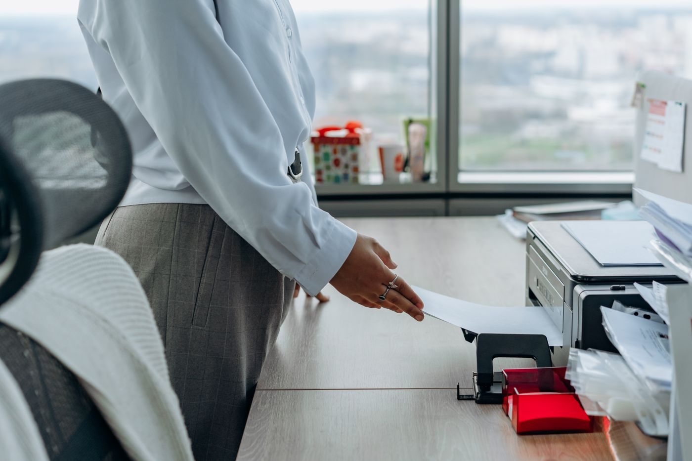 Mitarbeiterin am Drucker eines Büroarbeitsplatzes