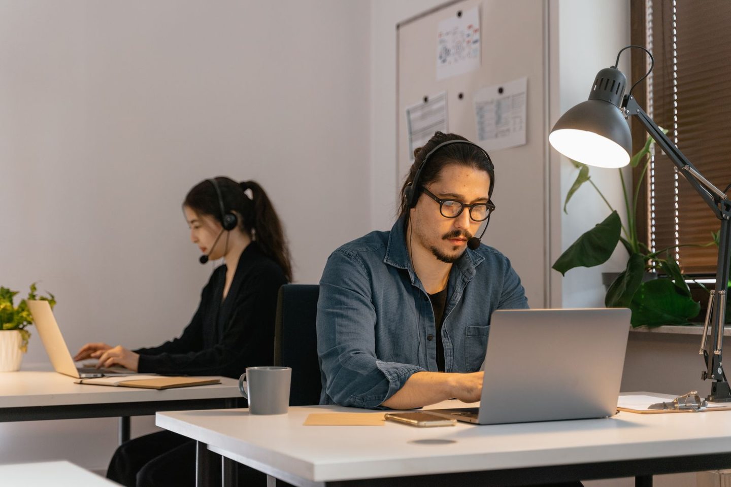 Mann mit Headset bei der Arbeit am Notebook