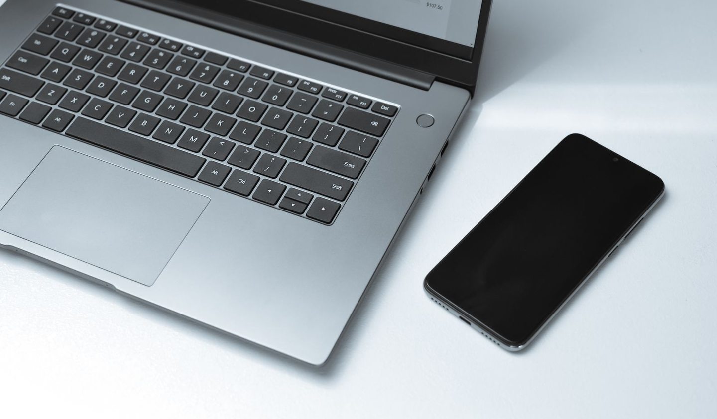 Notebook und Smartphone auf einer hellen Arbeitsfläche